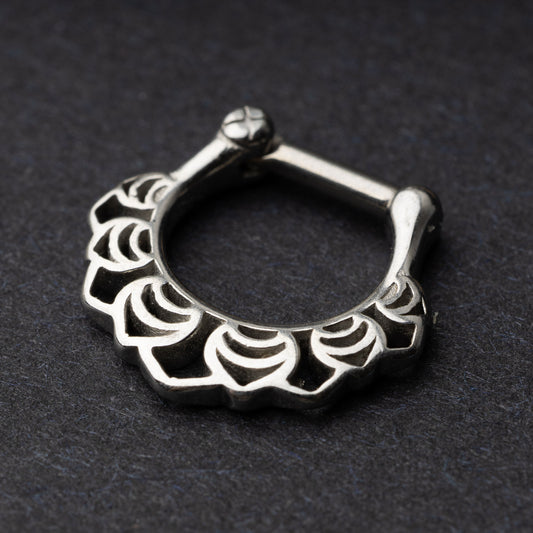 Close-up of a silver septum clicker with an Art Deco-inspired scalloped design, displayed on a dark background with a secure hinged clasp.