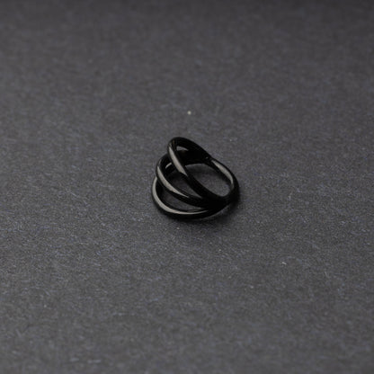 Four triple-band hoop septum clicker ring in black finish, displayed on a dark background.
